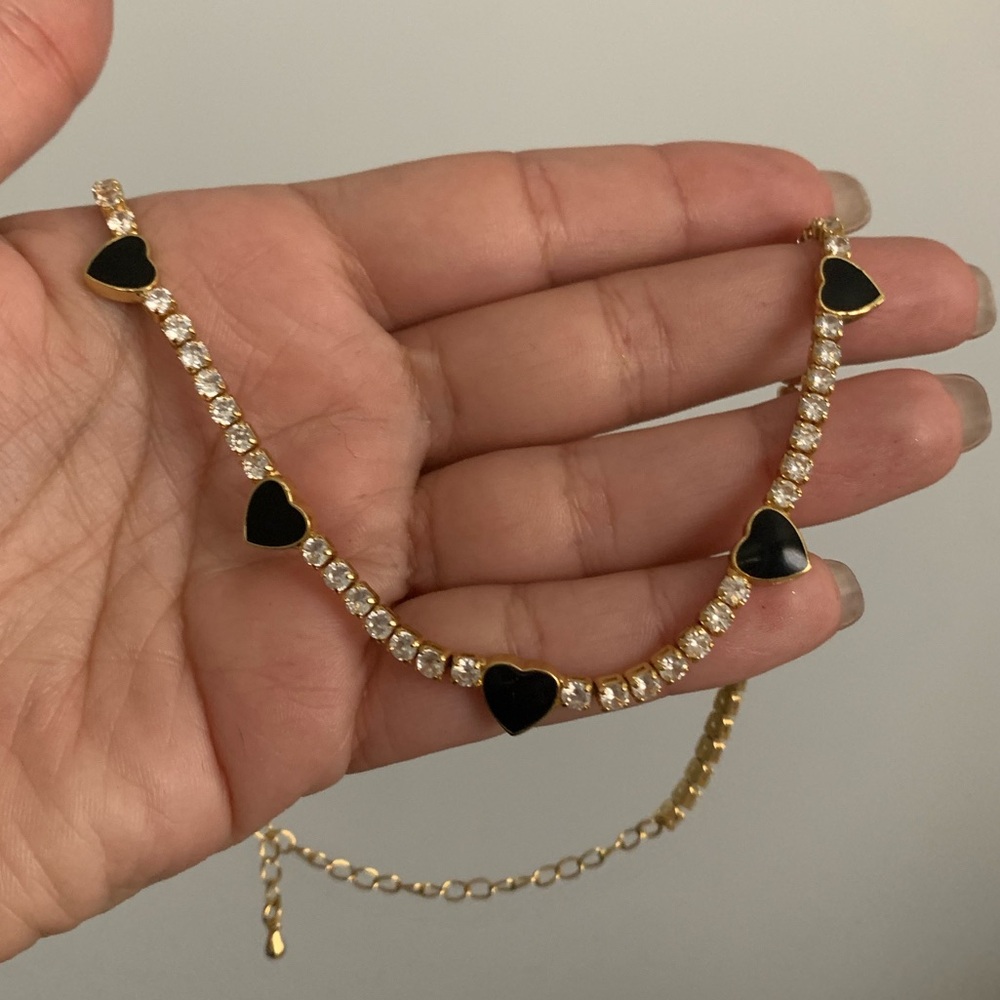 Goldtone tennis choker with enamel black heart stations